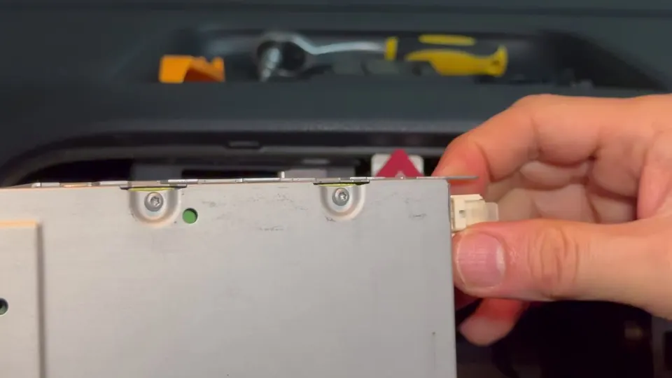 Unplugging the white Fakra connector from the back of the factory unit